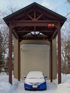 A Japanese car in front of a garage